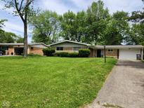 Charming ranch home with lush lawn, mature trees, and attached one car garage at 4125 Dequincy St, Indianapolis, IN 46226