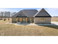 Charming brick home featuring a welcoming porch with timber supports and a beautifully landscaped yard at 5189 Abbeygate Blvd, Bargersville, IN 46106