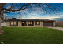 Charming single-story home featuring a stone facade, dark trim, manicured lawn, and a welcoming front entrance at 710 Erber Ct, Indianapolis, IN 46217