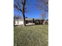 Charming single-story brick home with a two-car garage, covered porch, and well-maintained lawn at 7632 S Sherman Dr, Indianapolis, IN 46237