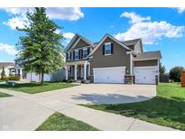 Inviting two-story home showcasing a three-car garage, manicured lawn, and tasteful architectural details at 7710 Eagle Crescent Dr, Zionsville, IN 46077