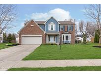 Charming two-story home with a well-manicured lawn, brick accents, and a two car garage at 8330 Harrison Pkwy, Fishers, IN 46038