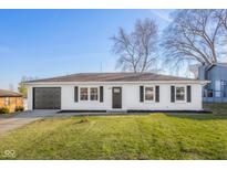 Charming ranch home featuring white siding, black shutters and a well-maintained front lawn, great curb appeal at 1319 Brookside Dr, Columbus, IN 47201