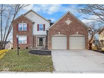 Charming two-story brick home featuring a well-manicured lawn and attached two-car garage at 13812 Barnett Pl, Fishers, IN 46038