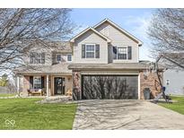 Charming two-story home featuring a brick facade, a welcoming front porch, and an attached two-car garage at 15101 Proud Truth Dr, Noblesville, IN 46060