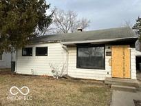 Exterior view of a single-story home featuring white siding and black-trimmed windows at 1827 N Whittier Pl, Indianapolis, IN 46218