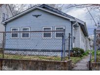 Quaint home featuring light blue siding, white trim, and a decorative eagle perched above the windows at 1937 N Lasalle St, Indianapolis, IN 46218