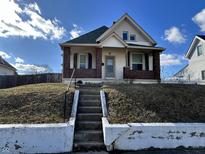Charming two-story home featuring brick accents, inviting front porch, and a well-maintained lawn at 218 S 5Th Ave, Beech Grove, IN 46107