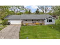 Charming single story home featuring a gray roof, welcoming front porch, and well-manicured lawn at 2230 Mindy Ct, Anderson, IN 46017