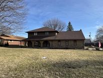 Charming brick two-story home featuring a large front yard and covered porch at 3515 Beechwood Ln, Anderson, IN 46011
