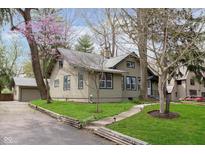 Charming two-story home with a well-maintained lawn, landscaped yard, and quaint walkway to the front door at 3750 Totem Ln, Indianapolis, IN 46208