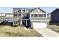 Beautiful two-story home with a two-car garage and well-manicured lawn at 6199 N Caraway Dr, McCordsville, IN 46055