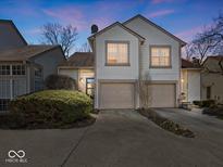 Charming two-story home with attached two-car garage and well-maintained landscaping at dusk at 6263 Behner Way, Indianapolis, IN 46250