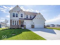 Charming two-story home with stone accents, three-car garage, and well-manicured lawn at 6323 Willow Branch Way, Plainfield, IN 46168