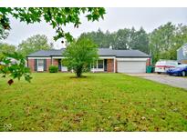 Charming single-story brick home with a well-manicured lawn and an attached two-car garage at 8172 Shottery Ter, Indianapolis, IN 46268