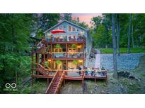 Multi-level home featuring wraparound decks, lush landscaping and lake views at 8205 Bass Dr, Nineveh, IN 46164