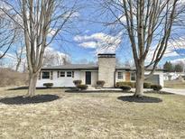 Charming single-story home with a stone chimney and well-maintained landscaping, offering great curb appeal at 8795 Carrollton Ave, Indianapolis, IN 46240
