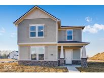 Two story home featuring beautiful stone accents and a covered porch at 9307 Harlow Way, Plainfield, IN 46168