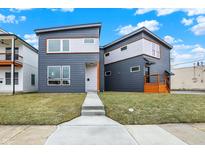 Inviting two-story home boasts a unique architectural style with modern gray siding and a well-manicured front lawn at 1024 Calvary St, Indianapolis, IN 46203