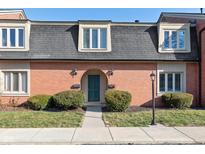 Charming brick condo featuring a well-manicured lawn, a dark roof, and dormer windows at 1138 Canterbury S Sq, Indianapolis, IN 46260