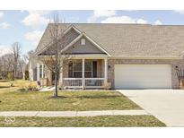 Charming brick home featuring an attached two-car garage and a cozy front porch at 1382 Redstone Dr, Avon, IN 46123