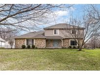 Charming two-story home with stone accents, a manicured lawn, and a well-maintained landscape with mature trees at 14485 Oak Ridge Rd, Carmel, IN 46032