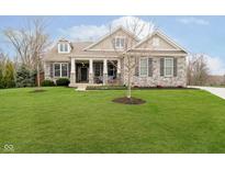 Charming stone home with a manicured lawn and covered front porch offers curb appeal at 15506 Slateford Rd, Noblesville, IN 46062