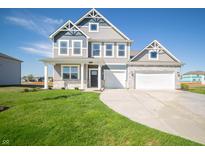 Charming two-story home with gray siding, white brick, an attached two car garage, and a manicured lawn at 2260 Oakmont Dr, Plainfield, IN 46168