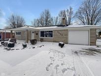 Charming single story home featuring stone exterior with attached garage and snow covered yard at 3025 E 6Th St, Anderson, IN 46012