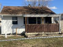 Cozy single-story home with a brown roof and a covered front porch and a chain-link fence at 3045 Asbury St, Indianapolis, IN 46237
