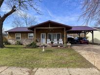 Charming home featuring a cozy front porch with white chairs and a convenient covered carport at 3066 Falcon Dr, Indianapolis, IN 46222