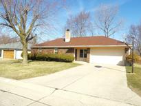 Brick home with manicured lawn, attached garage, and basketball hoop on a sunny day at 3534 Country Walk Dr, Indianapolis, IN 46227