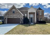 Two-story brick home with a two-car garage and a turret on a sunny day at 4309 Worchester Ct, Carmel, IN 46033