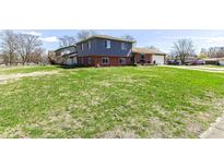Spacious front yard showcasing a multi-level home with a blend of siding and brick exterior at 5414 Honey Comb Ln, Indianapolis, IN 46221