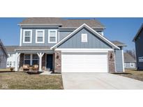 Charming two-story home with a two-car garage, brick accents, and a covered front porch at 5462 Wood Spg Ln, McCordsville, IN 46055