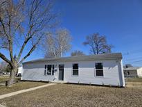 Charming one-story home with a well-manicured front lawn and mature trees at 702 Eberhart Dr, Shelbyville, IN 46176