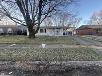Charming single-story home with a covered front porch and a driveway leading to a convenient carport at 8225 Crousore Rd, Indianapolis, IN 46219