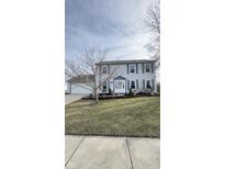 Charming two-story home featuring light blue siding, blue shutters, and a well-manicured front yard at 8271 Shattuck Dr, Avon, IN 46123