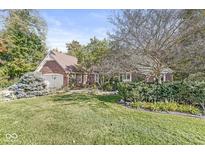 Charming brick home features a well-manicured lawn and mature trees creating a warm, inviting curb appeal at 8425 N Halyard N Way, Indianapolis, IN 46236