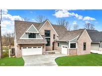 Beautiful brick home featuring a three-car garage, manicured lawn, and complementary gray and white trim at 908 Oak Terrace Rd, Westfield, IN 46074