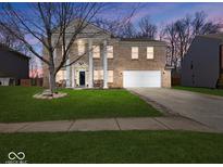 Inviting two-story brick home featuring classic columns, a well-manicured lawn, and a two-car garage at 10090 Eagle Eye Way, Indianapolis, IN 46234