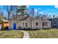 Charming single-story home featuring a bright blue door, neutral siding, and a well-maintained front yard at 1023 Helen Dr, Indianapolis, IN 46240