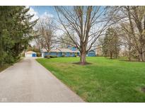 Long driveway leading to a lovely blue home with a spacious front yard and mature trees, perfect for outdoor enjoyment at 1250 W 141St St, Carmel, IN 46032
