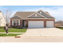 Charming single Gathering home featuring a brick facade, an attached 3 car garage, and a wide concrete driveway at 1590 Blackthorne N Trl, Plainfield, IN 46168