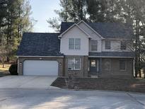Charming two-story home featuring a brick facade, attached garage, and well-maintained front yard at 293 Spruce Ct, Martinsville, IN 46151