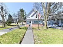 Charming two-story home with an American flag displayed out front and inviting front porch at 302 S Sherman Dr, Indianapolis, IN 46201