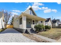 Charming home with light siding, white brick accents, covered porch, and gravel driveway at 39 S Holmes Ave, Indianapolis, IN 46222