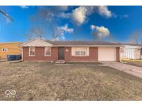 Charming brick home featuring an attached garage and a well-manicured front lawn at 4132 Richelieu Rd, Indianapolis, IN 46226