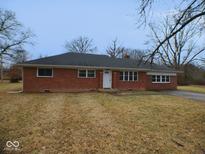 Charming single-story red brick home with a well-maintained front lawn and classic architectural details at 4530 Wichser Ct, Indianapolis, IN 46228