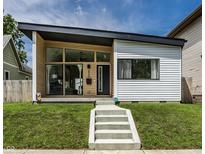 Contemporary home featuring a striking asymmetrical roofline and large windows, set against a lush green lawn at 632 N Temple Ave, Indianapolis, IN 46201